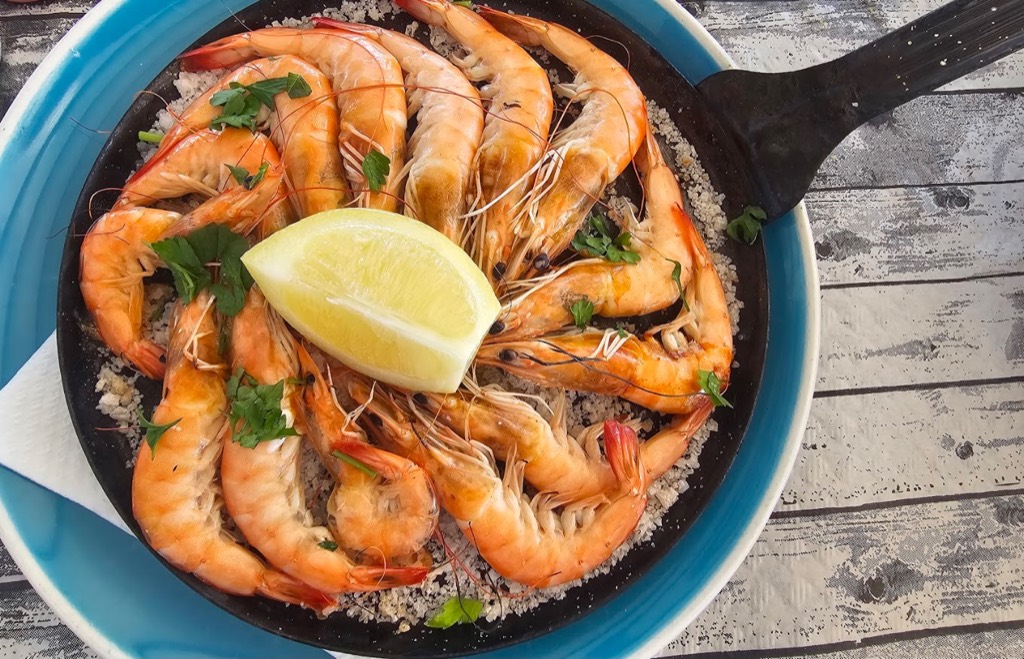 Langostinos a la plancha sobre sal con limón y perejil en El Charcón, Lanzarote