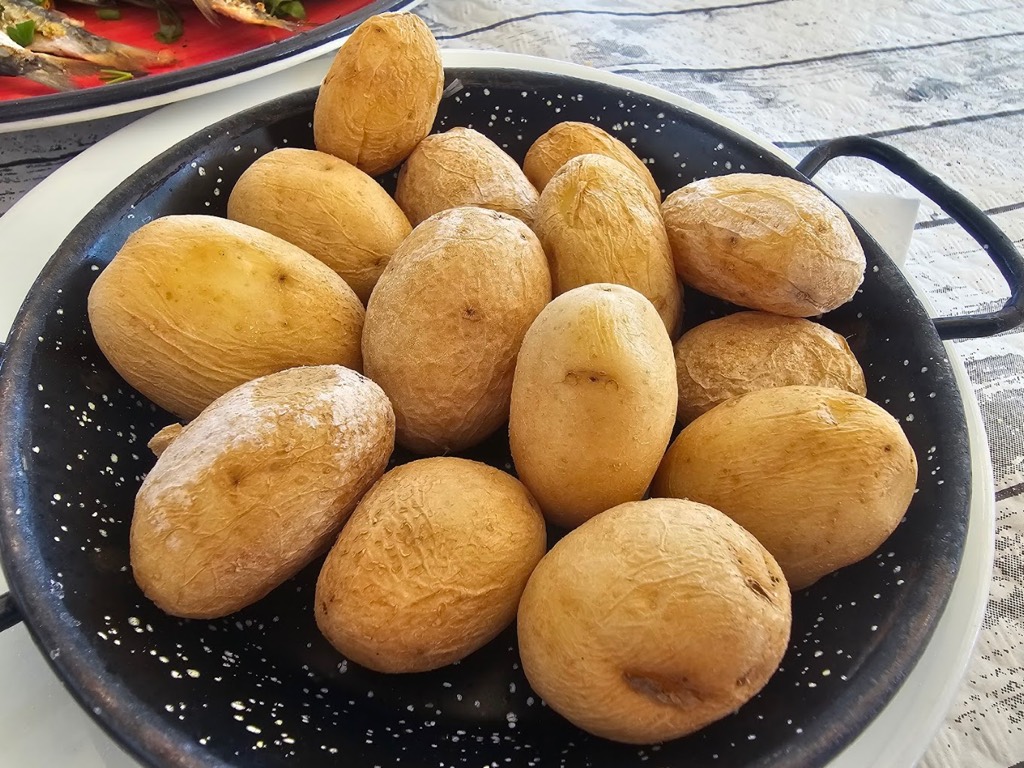 Papas arrugadas canarias servidas en cazuela de barro en El Charcón, Arrieta