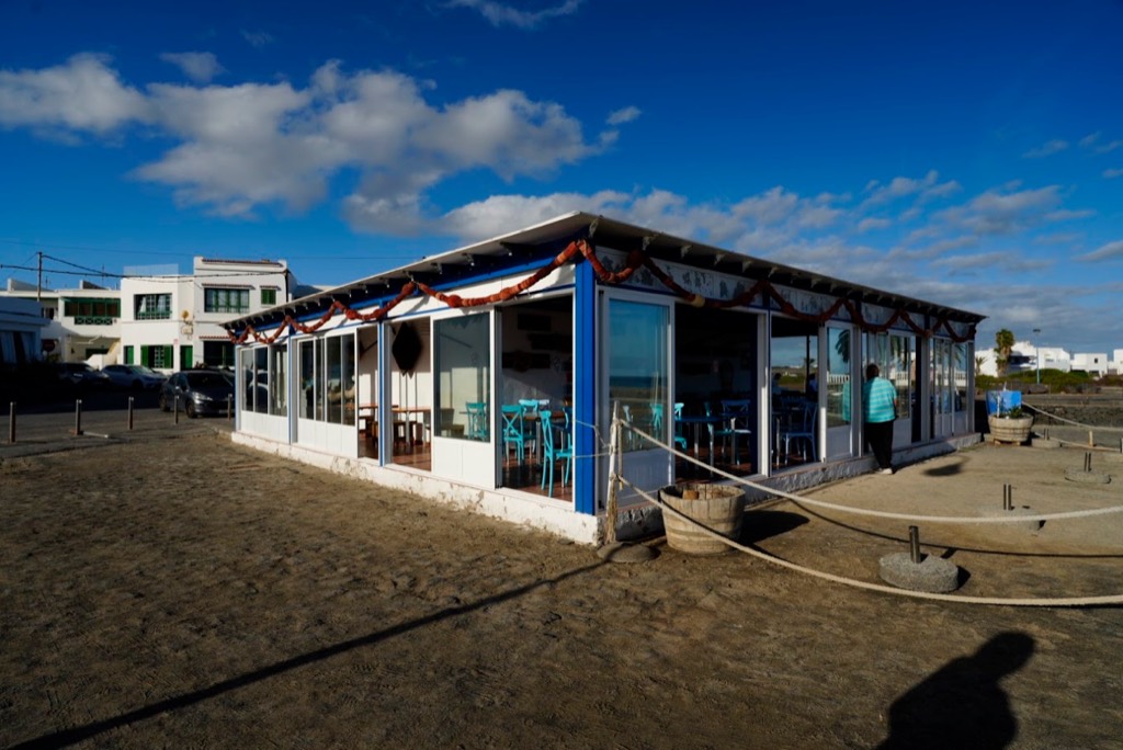 Fachada del Restaurante El Charcón sobre la arena del muelle de Arrieta, Lanzarote